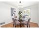 Bright dining area with a round glass table, four chairs, and modern light fixture at 801 N Evelyn Nw, Atlanta, GA 30318
