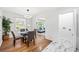 Bright dining area with a round glass table, hardwood floors, and views into the living room at 801 N Evelyn Nw, Atlanta, GA 30318