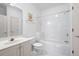 Bright white bathroom featuring a tub-shower combo, vanity with sink, toilet, and neutral wall decor at 1605 Ridenour Pkwy, Kennesaw, GA 30152