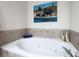 Bathroom features a large soaking tub with tile surround and decor on the walls at 1605 Ridenour Pkwy, Kennesaw, GA 30152