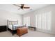 Bright bedroom with neutral decor, a black metal bed frame, plantation shutters, and dark wood furniture at 1605 Ridenour Pkwy, Kennesaw, GA 30152