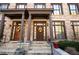 Inviting brick townhome entrance with columns and decorative wreaths on wooden doors at 1605 Ridenour Pkwy, Kennesaw, GA 30152