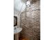 Unique half bathroom features brick accent wall, sleek sink and vanity, complemented by custom wallpaper and lighting at 1605 Ridenour Pkwy, Kennesaw, GA 30152