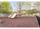 Community playground with slides, swings, and mature trees in a mulched play area at 1605 Ridenour Pkwy, Kennesaw, GA 30152