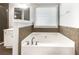 Relaxing bathroom featuring a garden tub with tile surround and separate vanity at 200 Pine Trl, Dallas, GA 30157