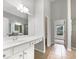 Bright bathroom featuring double sinks, vanity, tile flooring, with hallway view at 200 Pine Trl, Dallas, GA 30157