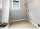 A laundry room with tile flooring, a window, and a single wire shelf at 200 Pine Trl, Dallas, GA 30157