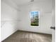 Bright walk-in closet with carpet flooring, wire shelving, and a window at 200 Pine Trl, Dallas, GA 30157