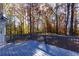 Backyard deck with view into the autumn trees and wooded area behind the home at 2001 Towne Lake W Hls, Woodstock, GA 30189