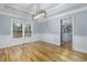 Bright dining room features hardwood floors, modern light fixture, and large window overlooking the yard at 2001 Towne Lake W Hls, Woodstock, GA 30189