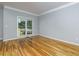 Empty room with hardwood floors, crown molding, and a view of the yard at 2001 Towne Lake W Hls, Woodstock, GA 30189