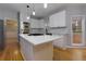 Modern kitchen featuring white cabinets, stainless steel appliances, and center island with gas cooktop at 2001 Towne Lake W Hls, Woodstock, GA 30189