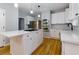 Modern kitchen featuring white cabinets, stainless steel appliances, and center island with gas cooktop at 2001 Towne Lake W Hls, Woodstock, GA 30189