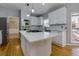 Well-lit kitchen with a center island, white cabinetry, stainless steel appliances, and view to dining room at 2001 Towne Lake W Hls, Woodstock, GA 30189