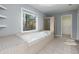 Main bathroom featuring a soaking tub, tiled floor and large window at 2001 Towne Lake W Hls, Woodstock, GA 30189