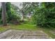 Brick patio area in back yard with grass and trees surrounding it at 2475 Harvel Nw Dr, Atlanta, GA 30318