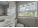 This bathroom has a mirror, toilet, sink and a window at 2475 Harvel Nw Dr, Atlanta, GA 30318