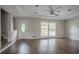 Spacious, sunny living room with hardwood floors, a tray ceiling, and a view of the front yard at 2475 Harvel Nw Dr, Atlanta, GA 30318