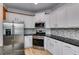 Modern kitchen with stainless steel appliances, white cabinets, and backsplash at 81 Richmond Way, Villa Rica, GA 30180