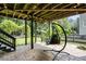 Under-deck patio featuring hanging chair, ceiling fan, and a view of the lush, landscaped backyard at 81 Richmond Way, Villa Rica, GA 30180