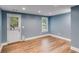 Light blue room with modern wood floors, a window, and a door to the backyard at 81 Richmond Way, Villa Rica, GA 30180