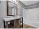 Bathroom with a vanity with shelves and a bathtub with shower at 1649 Southgate Mill Nw Dr, Duluth, GA 30096