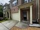 Close-up view of townhome entrance with attached garage and detailed landscaping at 1649 Southgate Mill Nw Dr, Duluth, GA 30096