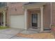 Brick facade of a townhome featuring an attached garage and a covered front entrance at 1649 Southgate Mill Nw Dr, Duluth, GA 30096