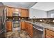 Gourmet kitchen featuring stainless steel appliances, granite countertops, and wooden cabinetry at 1649 Southgate Mill Nw Dr, Duluth, GA 30096