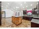 Open-concept living room and kitchen with glazed tile flooring, light walls, and a wood accent island and fireplace at 2711 Mcdonough Rd, Hampton, GA 30228