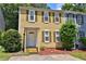 Charming two-story townhouse featuring a classic design with yellow siding and green shutters, surrounded by lush greenery at 4120 Buckley Woods Dr, Norcross, GA 30093