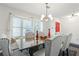 Dining room with white walls, light-colored dining chairs, chandelier, and a large window at 971 Clover Ln, Lawrenceville, GA 30044