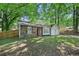 Home with a red door, stone facade, mature trees, and a lush green lawn at 971 Clover Ln, Lawrenceville, GA 30044