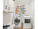 Convenient laundry room with modern washer and dryer, overhead storage, and neutral walls at 971 Clover Ln, Lawrenceville, GA 30044