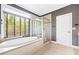 Modern bathroom featuring a soaking tub under a large window and a glass-enclosed shower at 1121 Vinings Grove Se Way, Smyrna, GA 30082