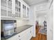 Butler's pantry with granite countertops, white cabinets, and access to the dining room at 1121 Vinings Grove Se Way, Smyrna, GA 30082