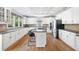 Well-lit kitchen with an island, stainless appliances, white cabinets, and hardwood floors at 1121 Vinings Grove Se Way, Smyrna, GA 30082