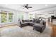 Bright open-concept living area features a gray sectional sofa, large windows and hardwood floors at 1121 Vinings Grove Se Way, Smyrna, GA 30082