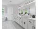 Bright, modern bathroom featuring double sinks, a large mirror, and marble floors at 3803 Upland Dr, Marietta, GA 30066