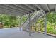 Spacious covered patio area with stairs leading to an upper deck and view of backyard at 3803 Upland Dr, Marietta, GA 30066