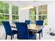 Dining area with big windows, modern table, and blue velvet chairs at 5264 Prestley Crossing Ln, Douglasville, GA 30135