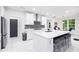 Modern kitchen features white cabinetry, island with seating, and stainless steel appliances at 5264 Prestley Crossing Ln, Douglasville, GA 30135