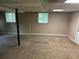 Finished basement space featuring carpeted floor, painted walls, and natural light from a window at 8415 Magnolia Dr, Jonesboro, GA 30238