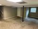 Spacious carpeted basement featuring neutral paint, drop ceiling, and natural light from a window at 8415 Magnolia Dr, Jonesboro, GA 30238