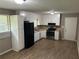 Kitchen features black appliances, white cabinets and laminate flooring at 8415 Magnolia Dr, Jonesboro, GA 30238