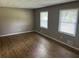 Living room features sleek laminate flooring and bright natural light from dual windows at 8415 Magnolia Dr, Jonesboro, GA 30238