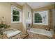 Bright bathroom with granite countertop and a tub next to a window at 1925 Waters Ferry Dr, Lawrenceville, GA 30043
