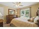 A carpeted bedroom features a ceiling fan, and a window view of the yard with lots of natural sunlight at 1925 Waters Ferry Dr, Lawrenceville, GA 30043