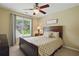 A cozy bedroom features a ceiling fan and a window view of the front of the house and the yard at 1925 Waters Ferry Dr, Lawrenceville, GA 30043