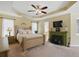 Spacious bedroom with a tray ceiling, ceiling fan, and a painted fireplace at 1925 Waters Ferry Dr, Lawrenceville, GA 30043